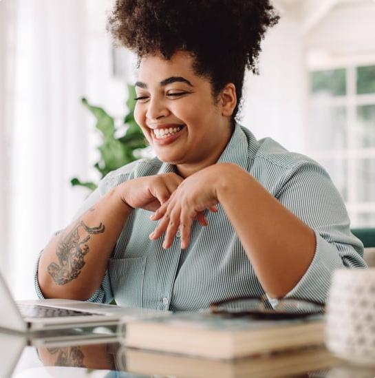 Arbor member smiling while using laptop at home.